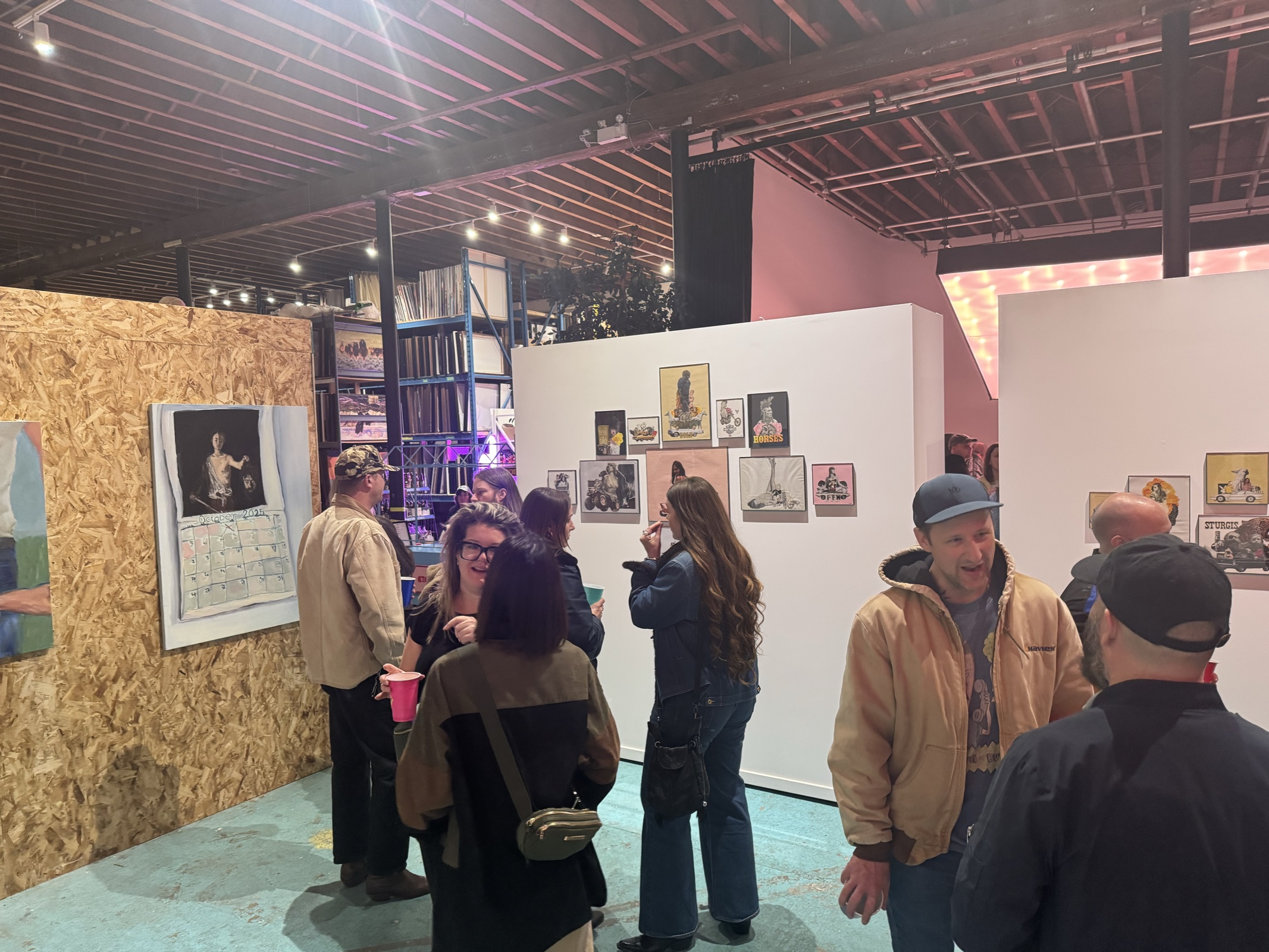 Guests viewing small works hung on gallery walls in the studio